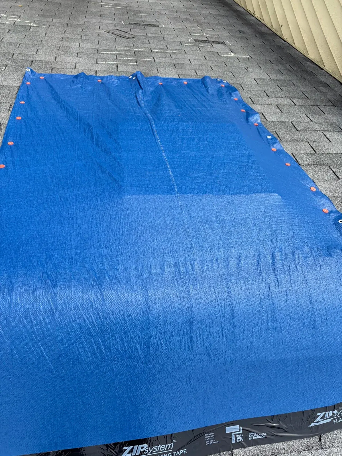 EMC emergency roof tarp with cap fasteners and flashing tape along the lower edge