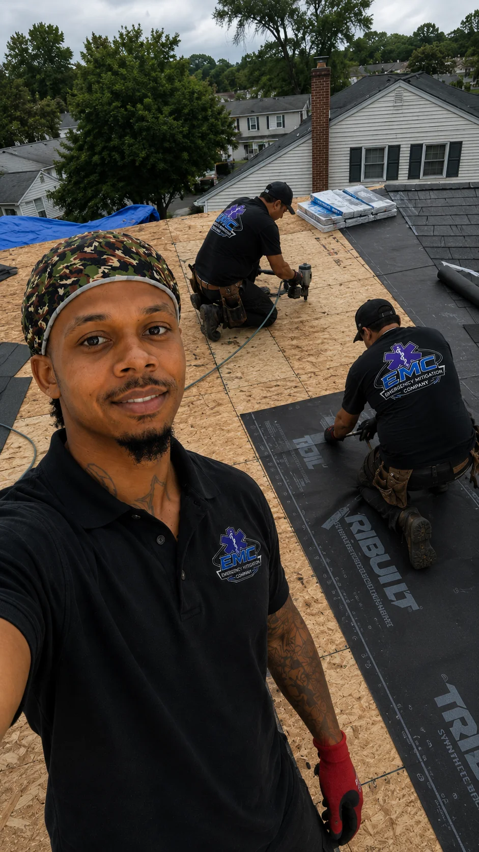 EMC Response crew re-decking and drying in a storm-damaged Maryland roof beside the emergency tarp they installed