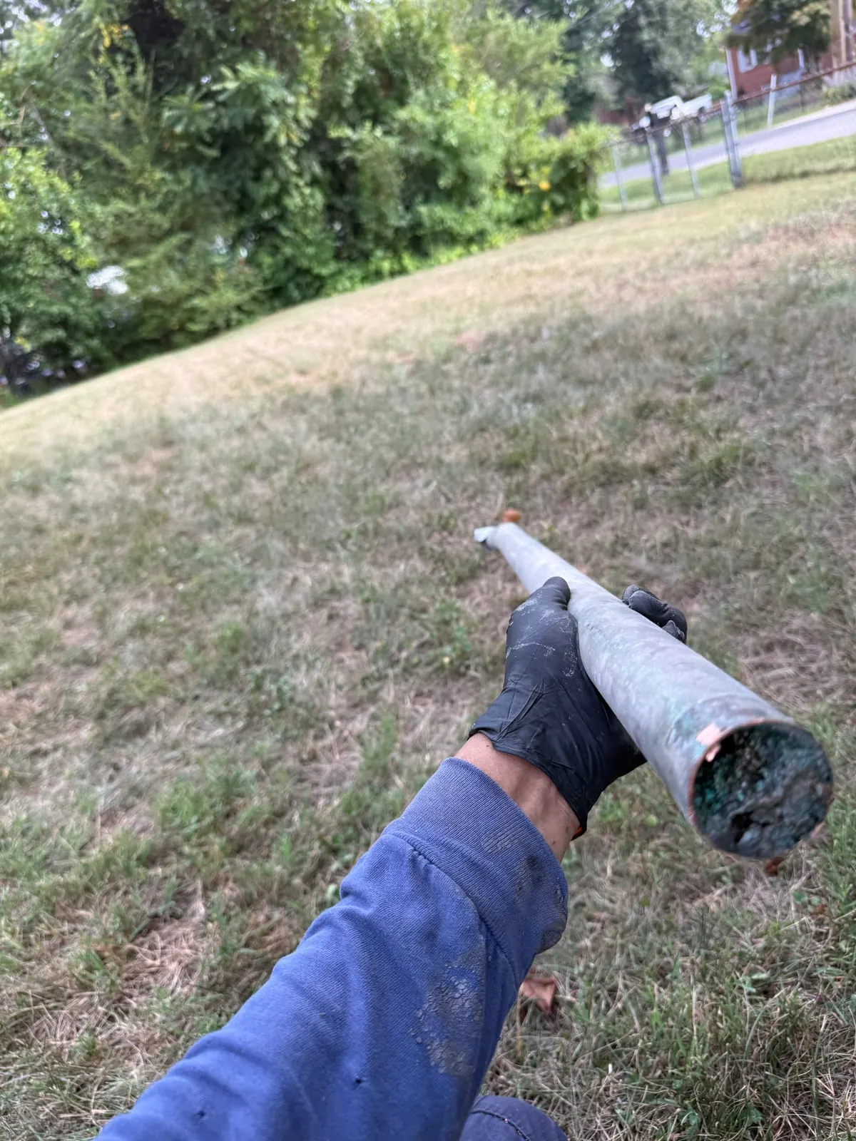 24/7 emergency plumber in Maryland — EMC Response technician holding a corroded copper supply line pulled during a same-night call