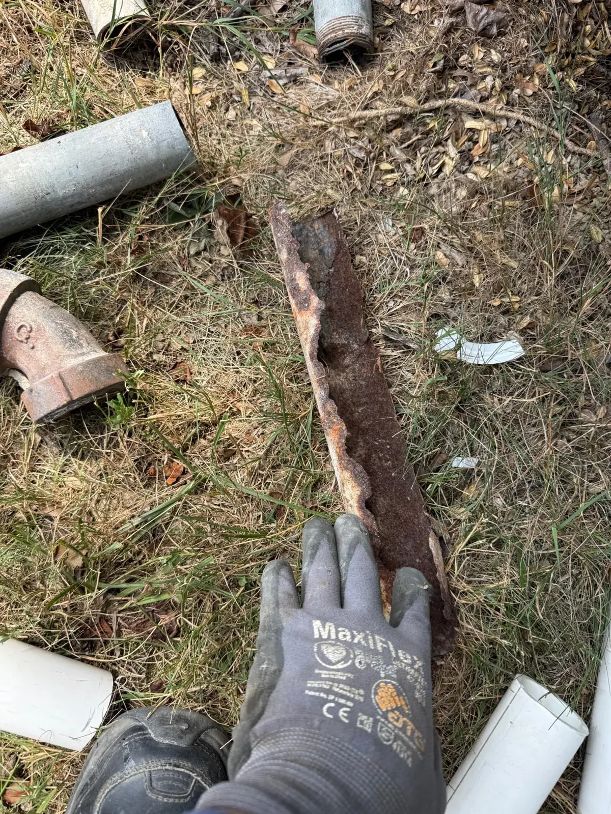 Rusted-through cast iron drain pipe removed during an EMC plumbing drain line replacement