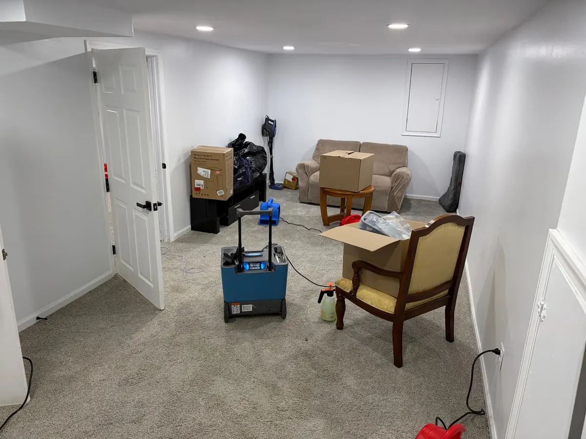 Basement water damage restoration in Maryland — EMC Response LGR dehumidifier and air movers drying a finished basement in place