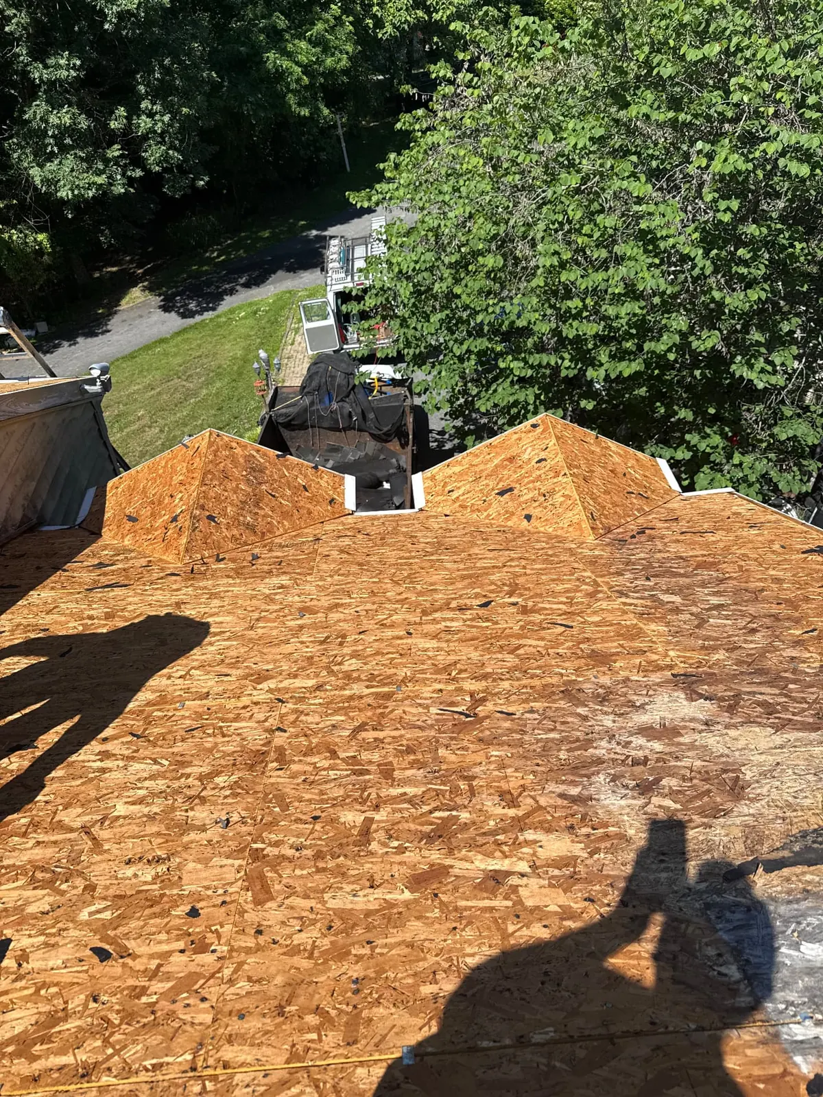 Roof replacement in Prince George's County, Maryland — EMC Response full tear-off with exposed OSB decking and dump trailer staged