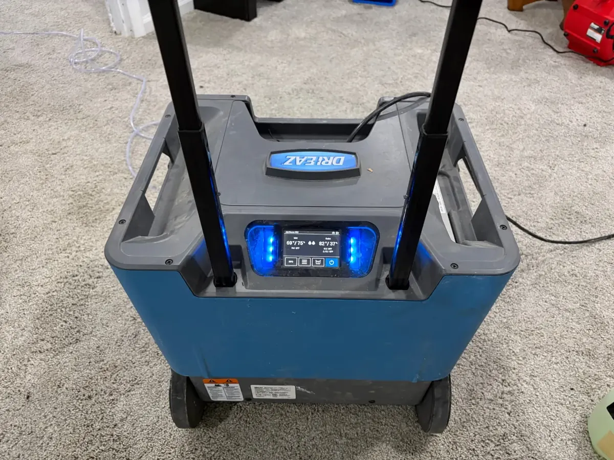 Dri-Eaz commercial dehumidifier running on carpet during EMC water damage structural drying