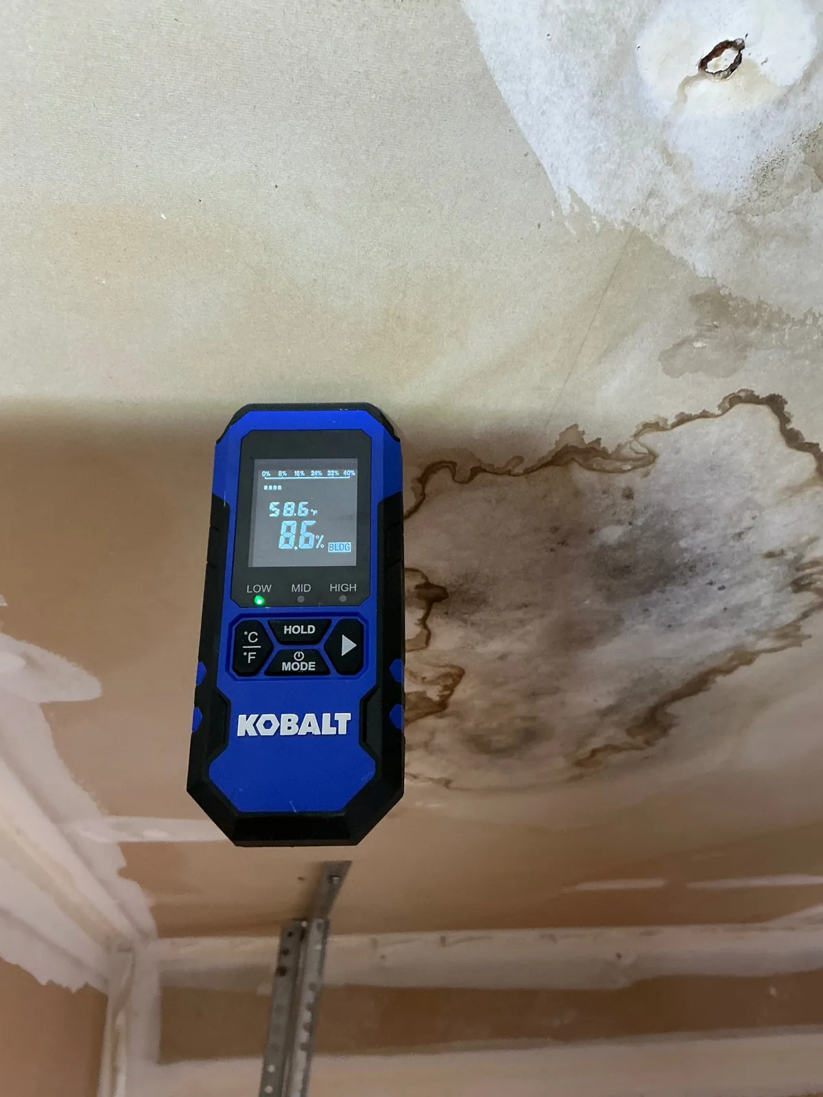 Water damage restoration in Bowie, Maryland — EMC Response moisture meter reading 8.6% on a water-stained ceiling